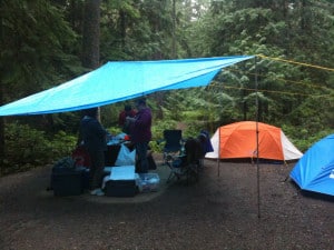 Dealing with rain in camp by setting up a tarp